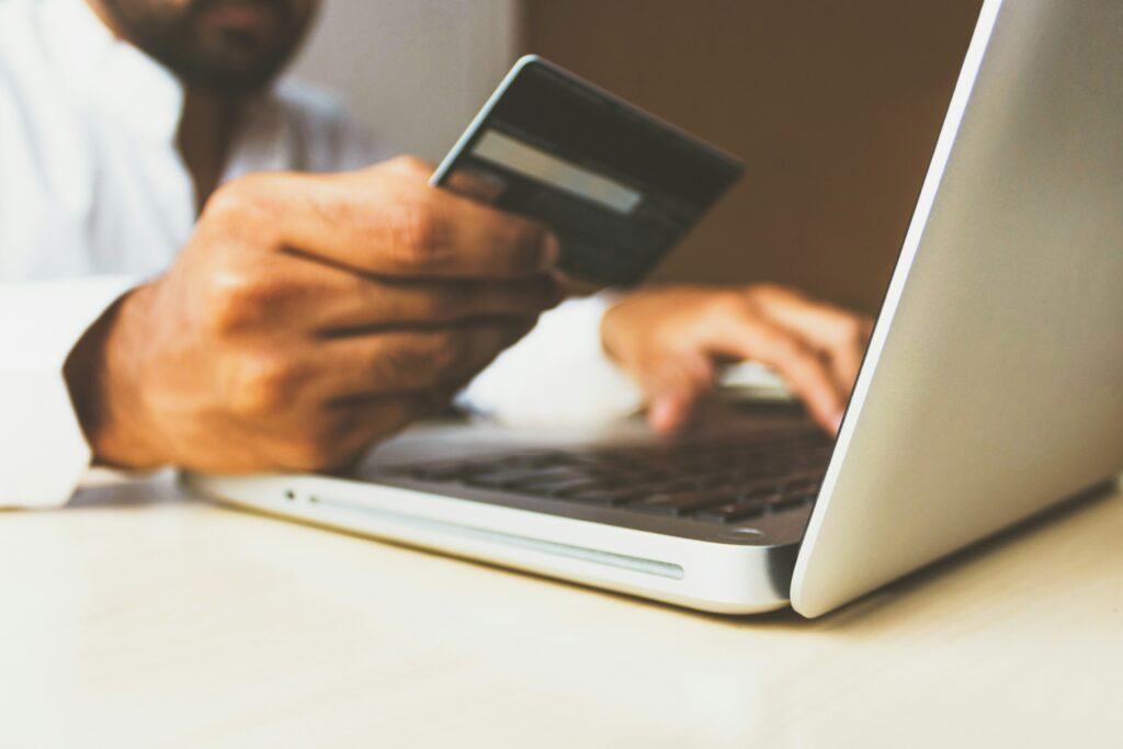 Persona pagando con tarjeta en una tienda online desde su laptop